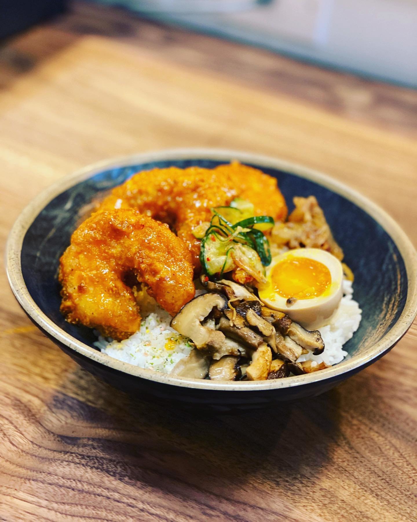 fried shrimp in a bowl with rice and toppings